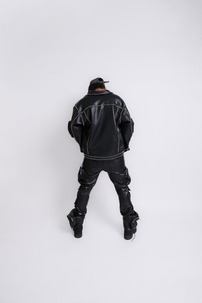 Person wearing a black leather jacket and pants on a white background