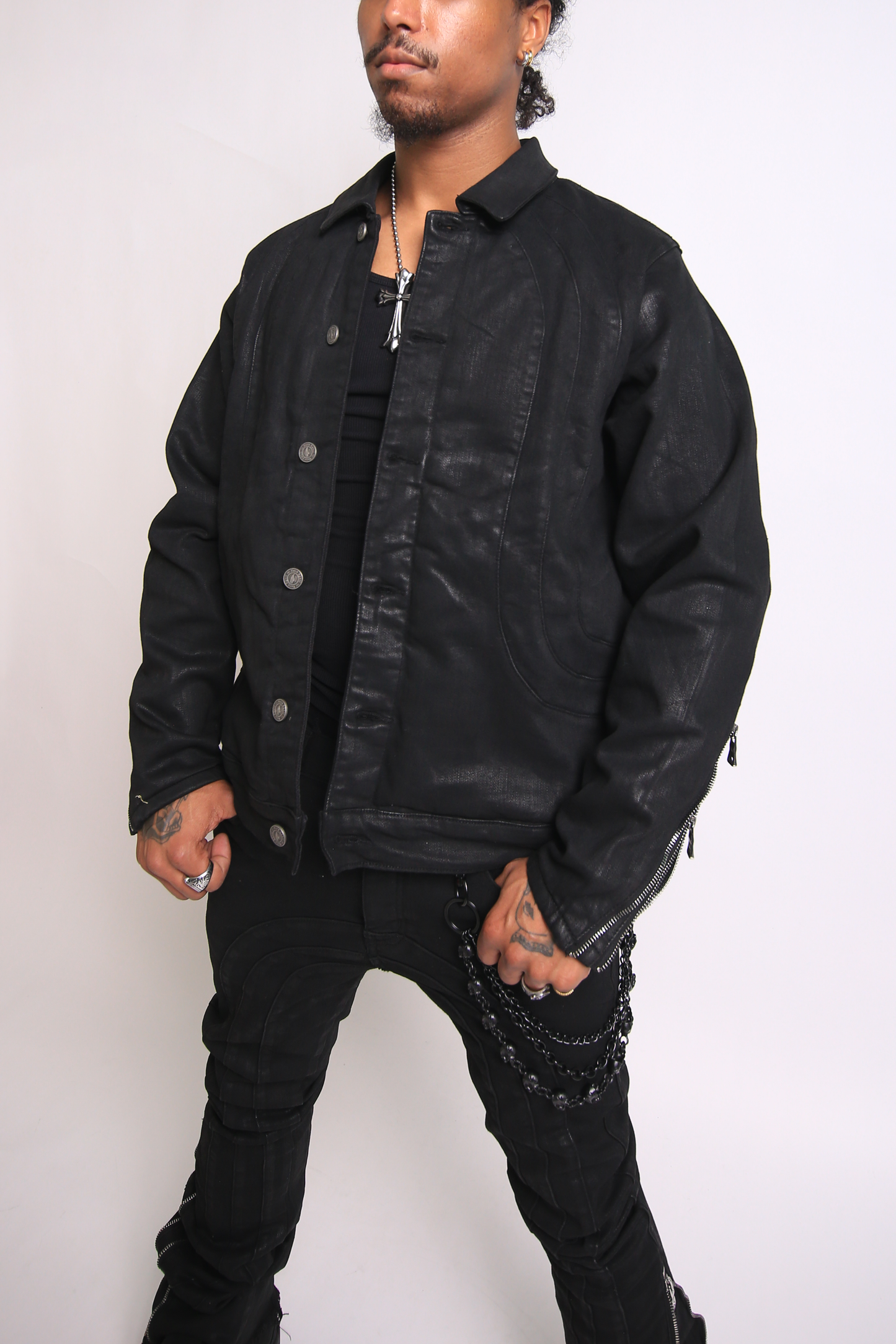 Man wearing a black jacket and pants against a white background