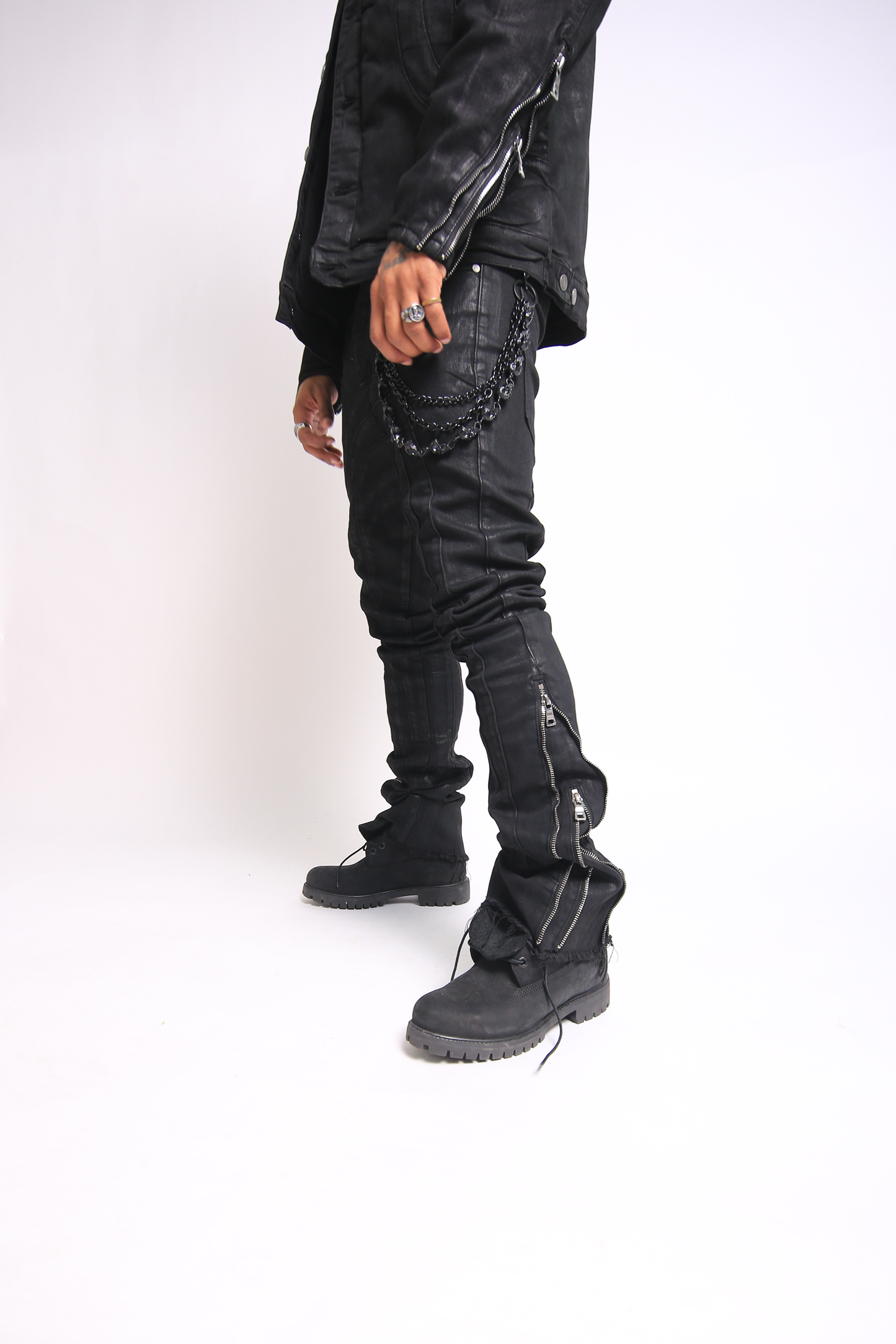 Person wearing black distressed jeans and boots on a white background