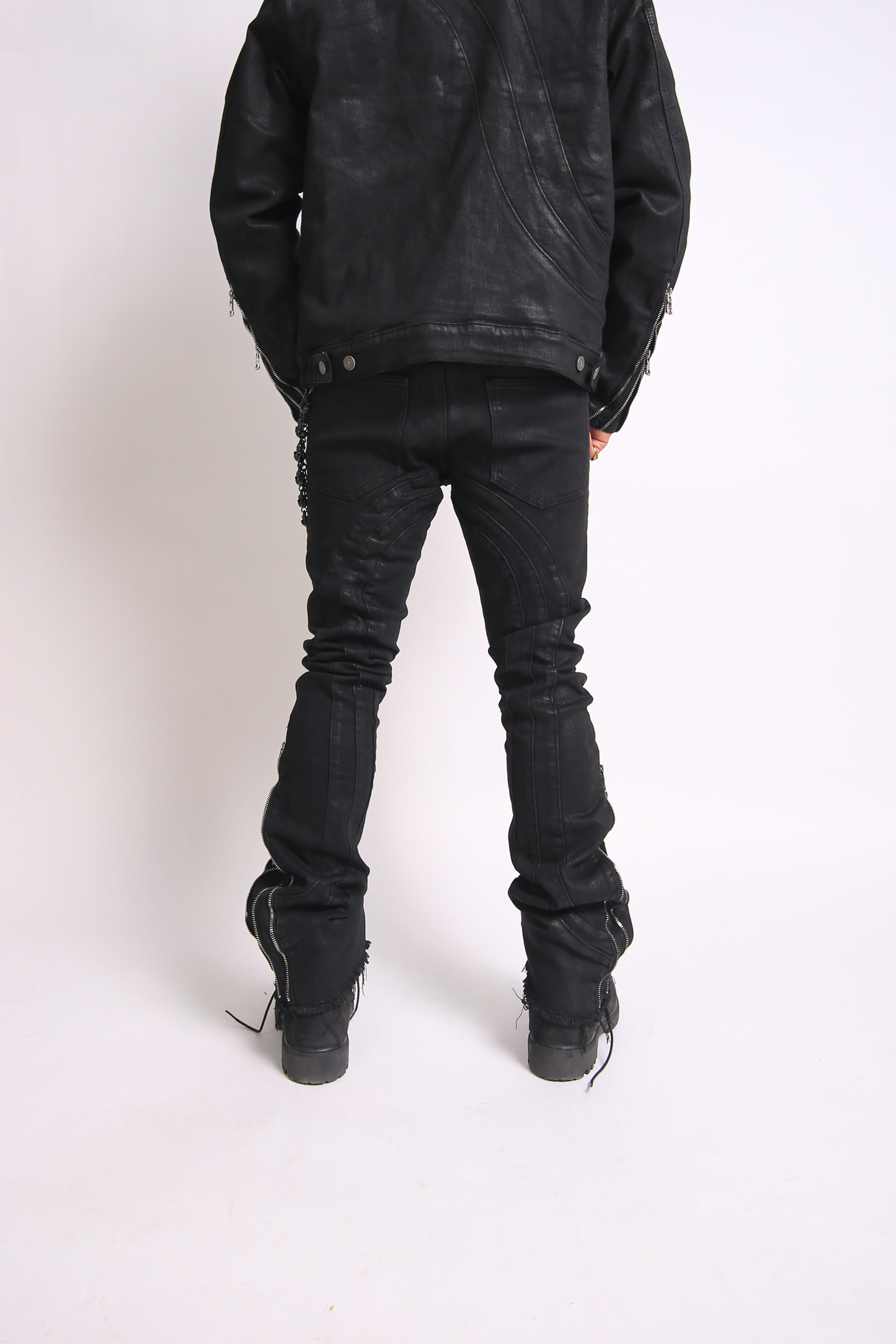 Person wearing black leather jacket and pants on a white background