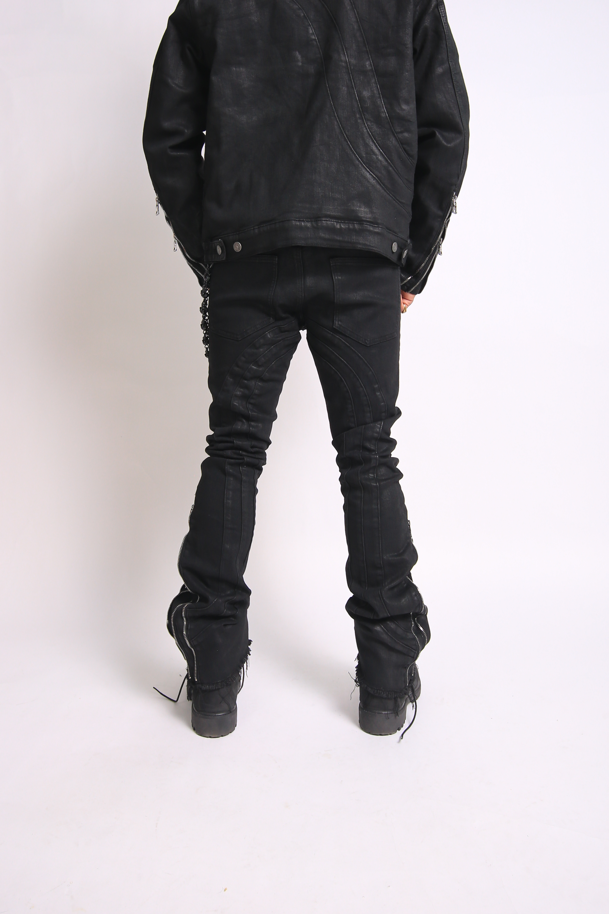 Person wearing black leather jacket and pants on a white background