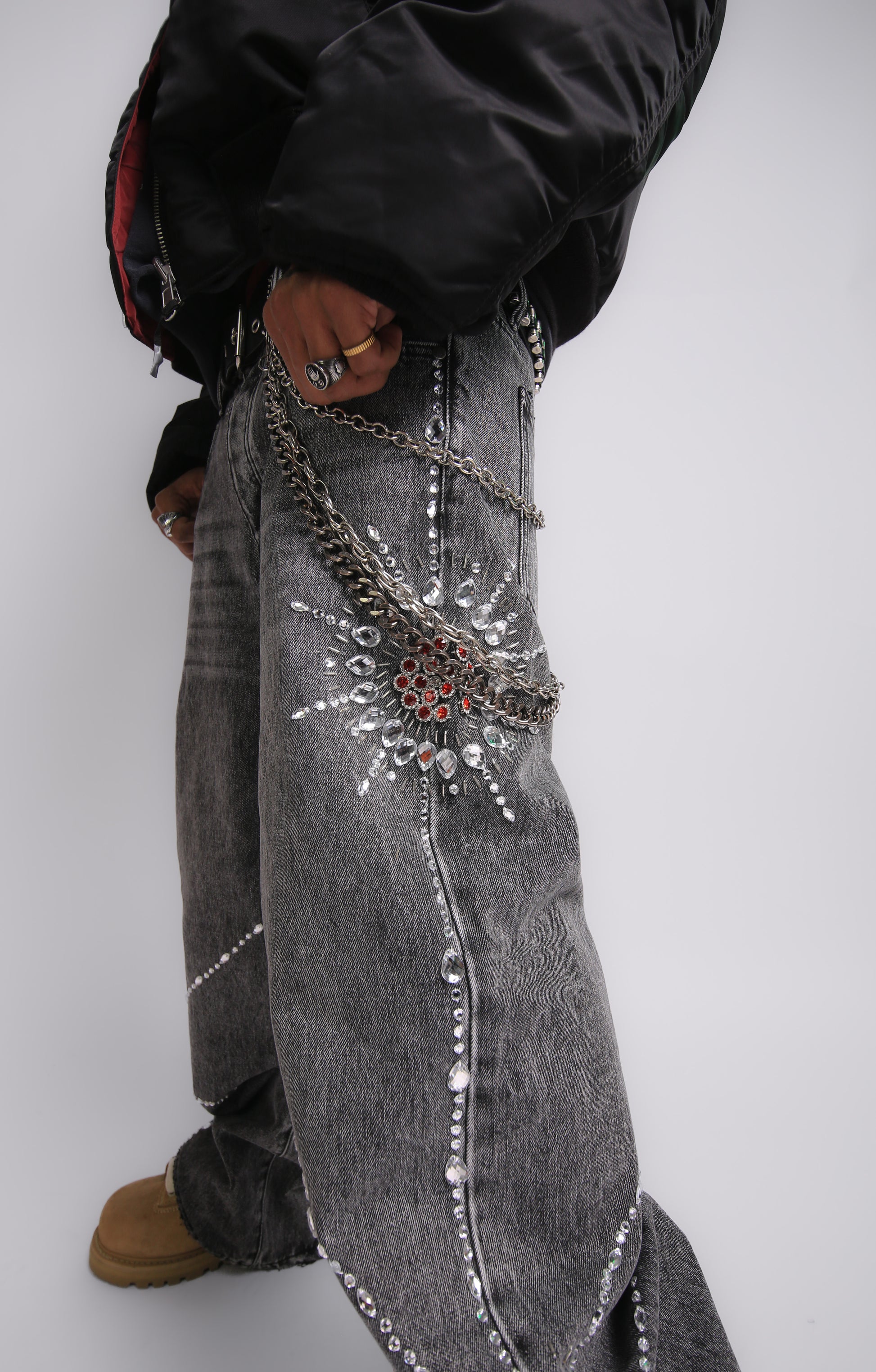 Person wearing embellished gray jeans with a white background