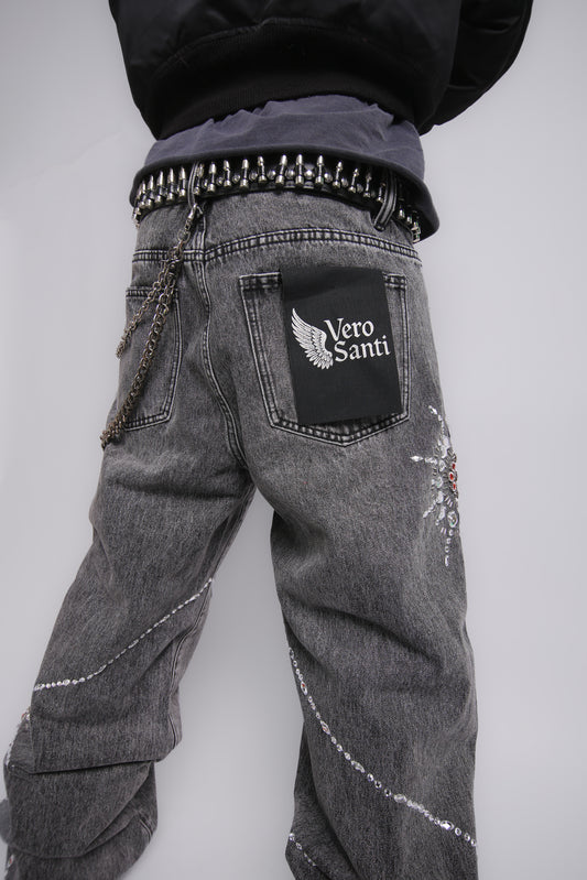 Gray jeans with decorative elements and a visible brand logo on a plain background
