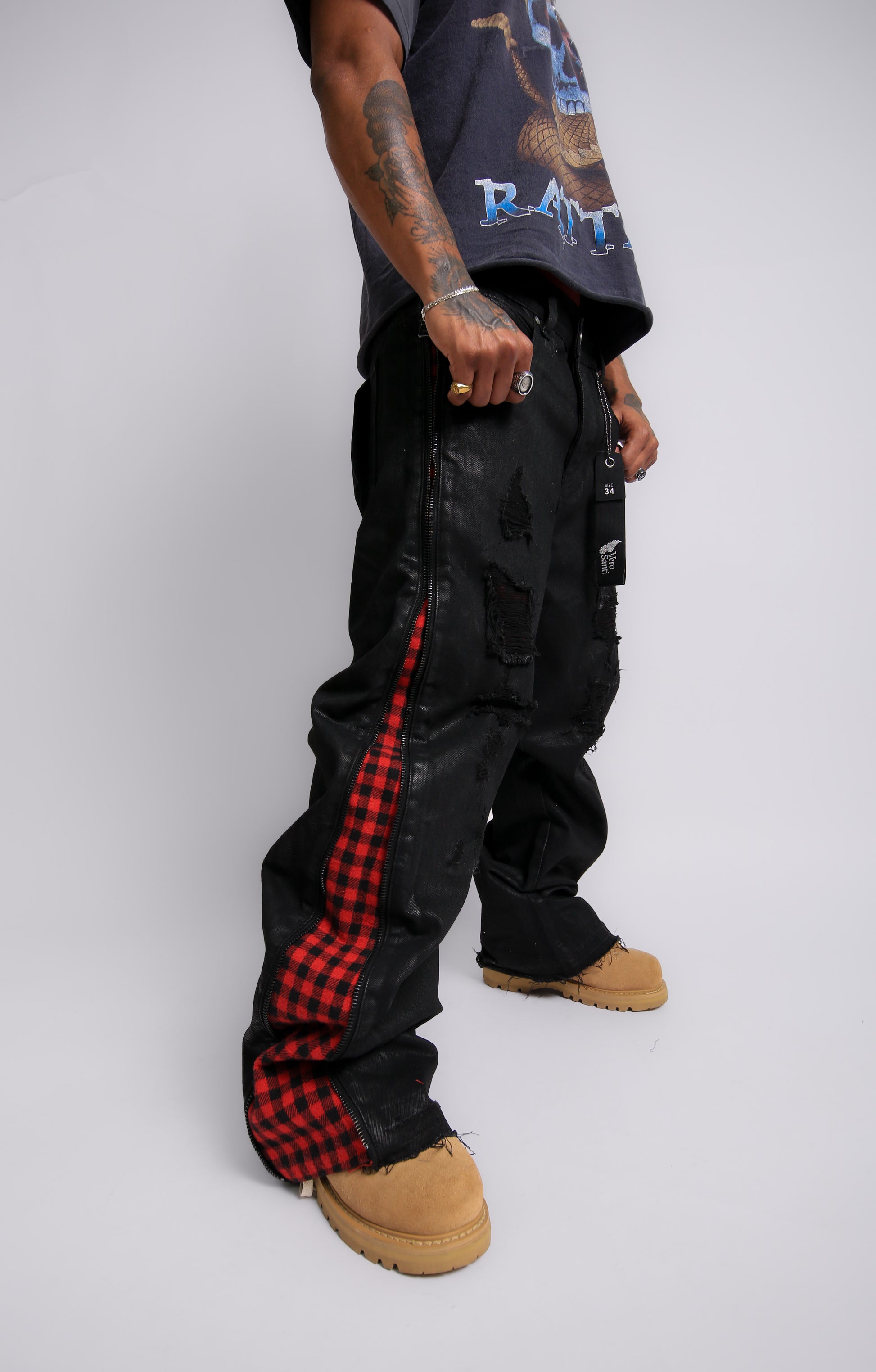 Person wearing black cargo pants with red plaid accents on a white background