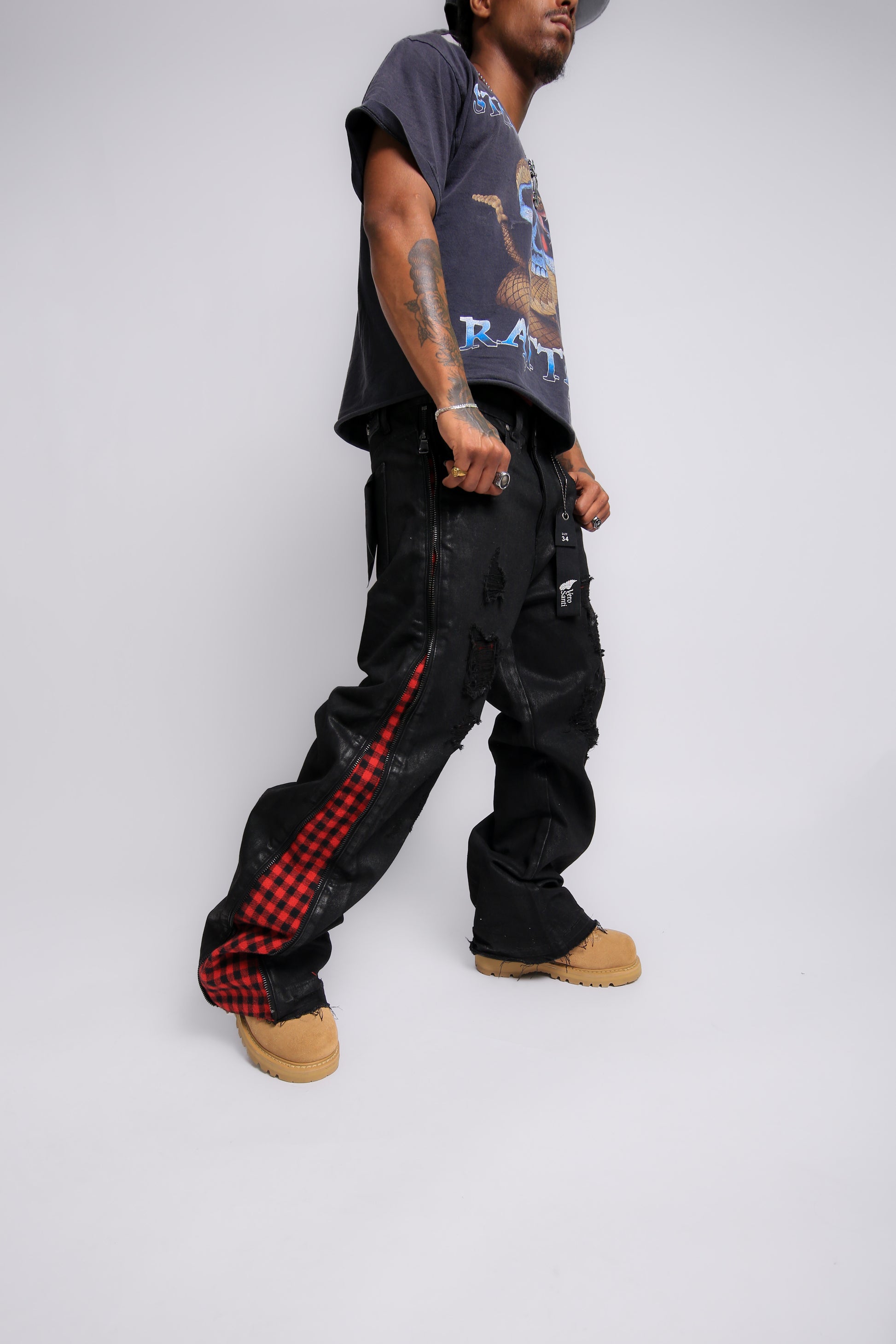 Person wearing black cargo pants with red checkered stripes on a white background