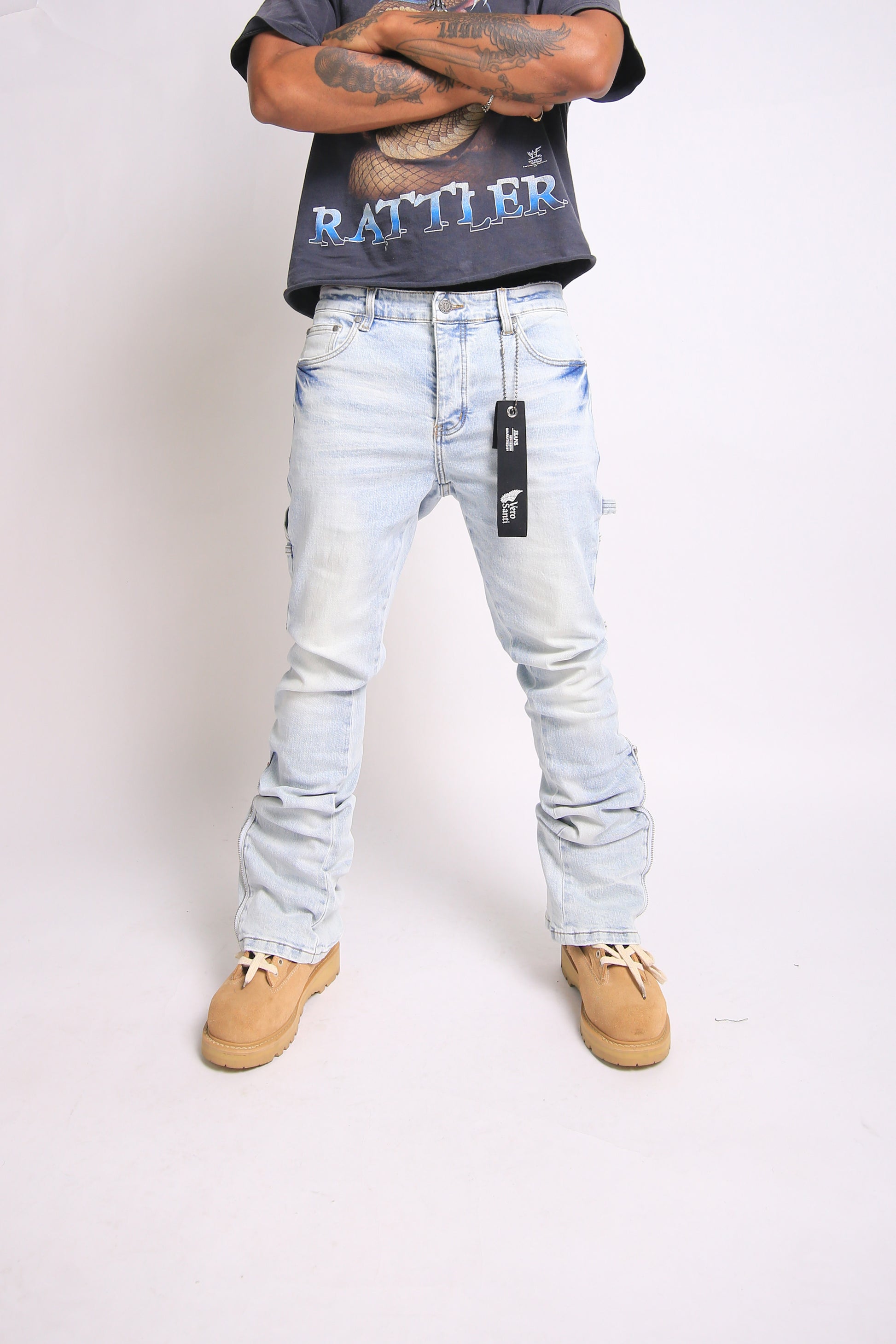 Light blue jeans with brand tag worn by a person on a white background