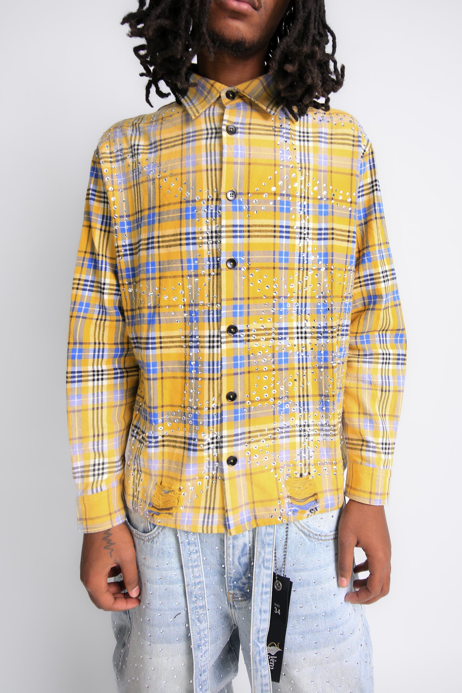 Person wearing a yellow plaid shirt with a plain background