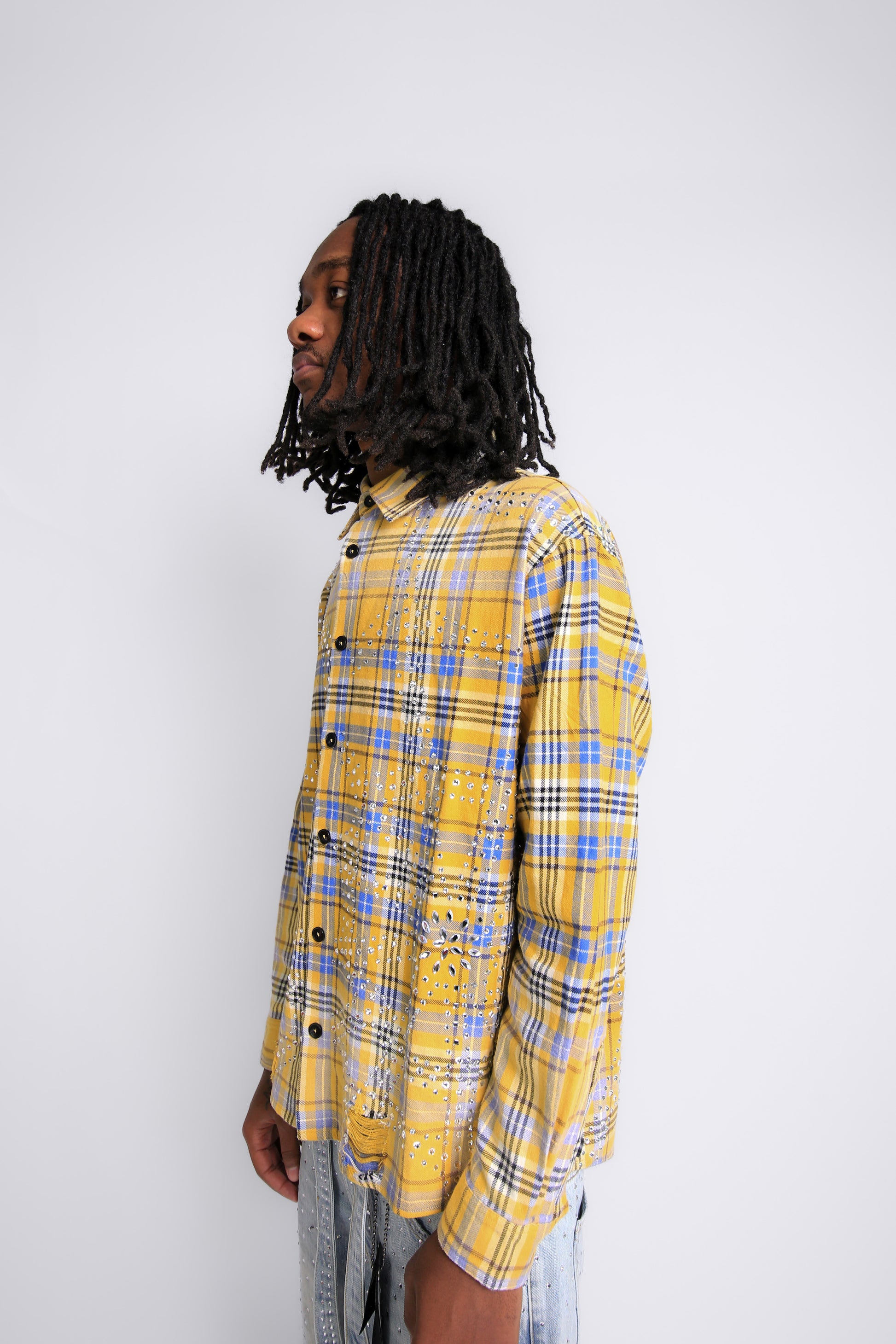 Person wearing a yellow and blue plaid shirt against a white background
