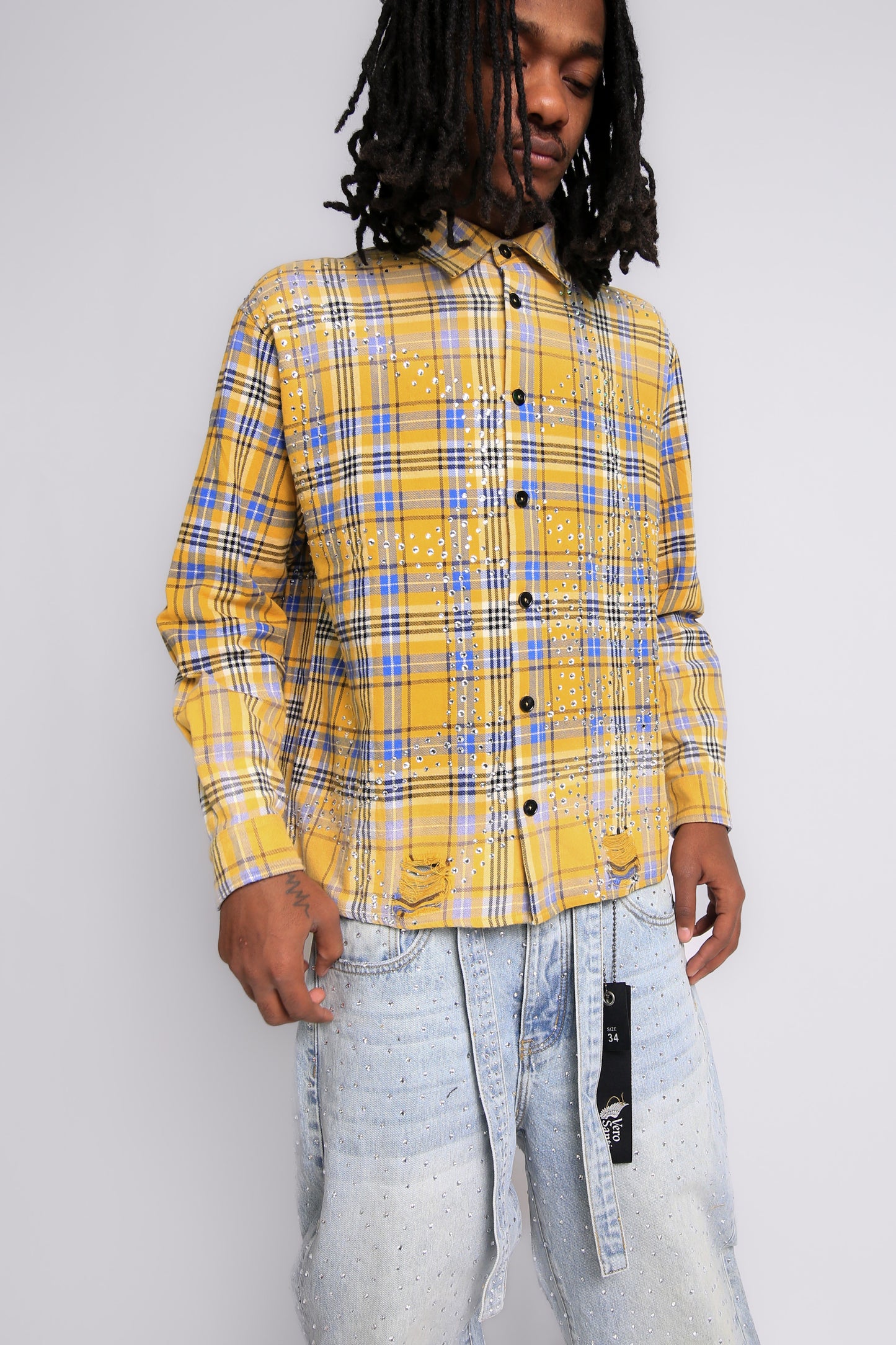 Person wearing a yellow plaid shirt with a plain background