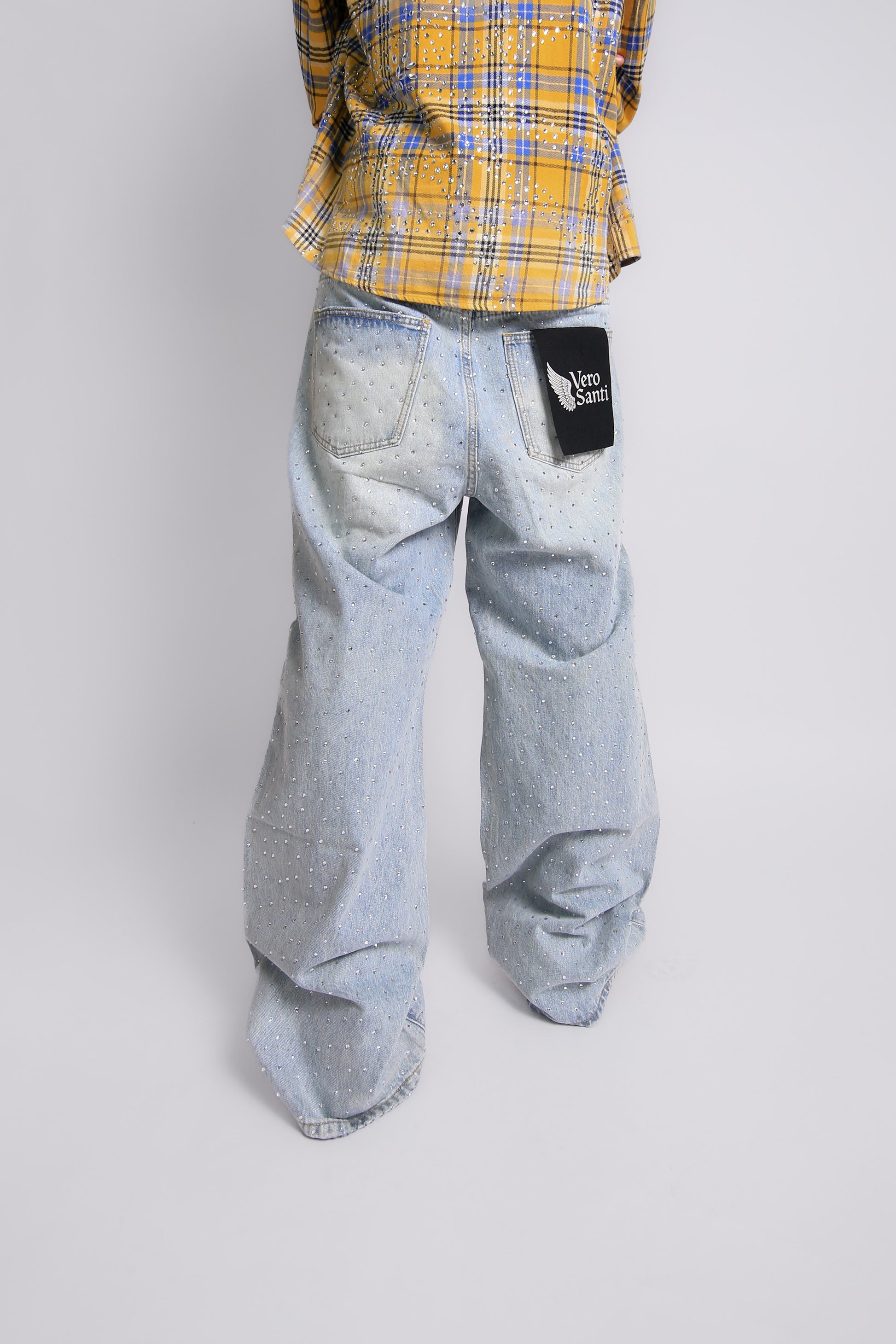 Light blue jeans with a black Vero Santi patch on a white background