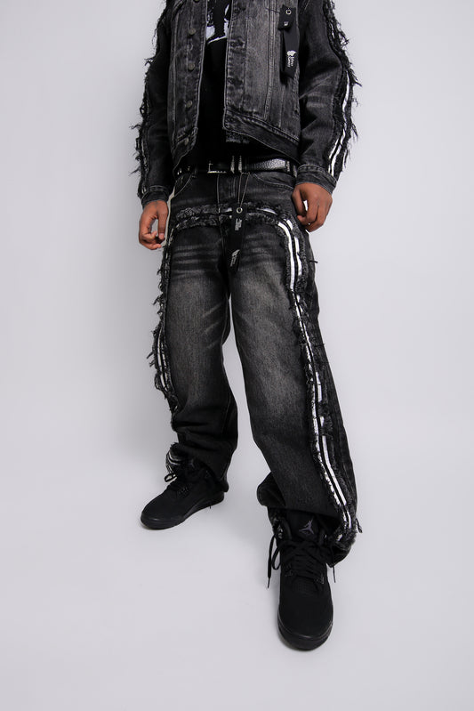 Person wearing a black distressed jacket, jeans, and boots on a white background