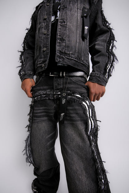 Person wearing a black distressed jacket and jeans on a white background