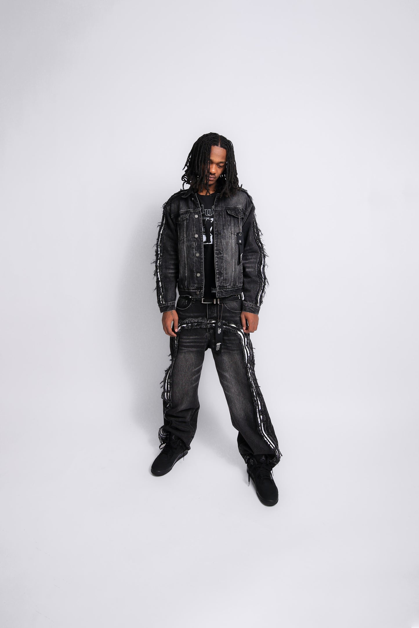 Person wearing a black denim outfit on a white background