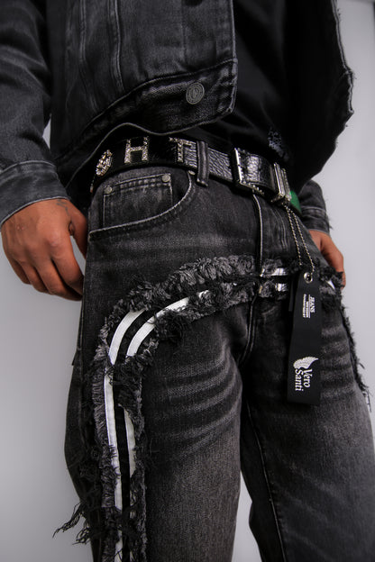 Person wearing black distressed jeans with a visible brand tag on a plain background