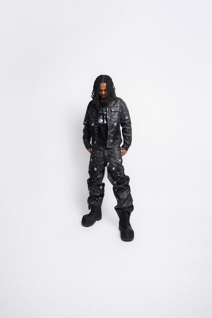 Person wearing a black leather jacket and leather pants on a white background