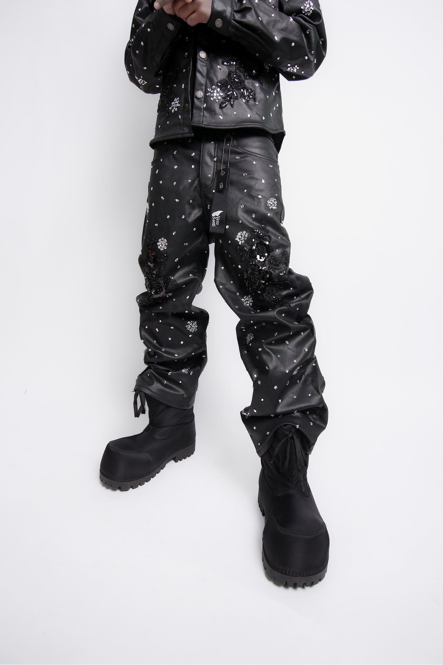 Person wearing black leather pants with white patterns on a white background