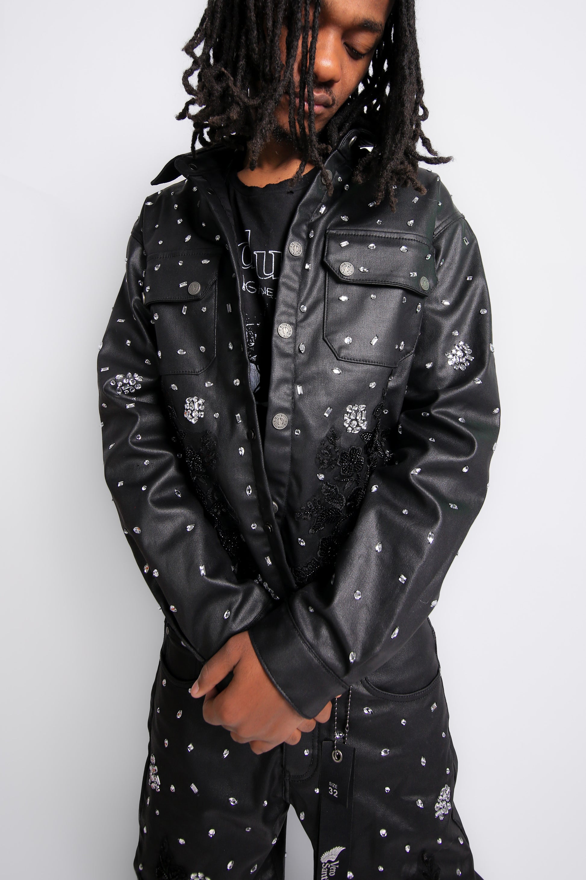 Person wearing a black leather jacket with white patterns on a white background