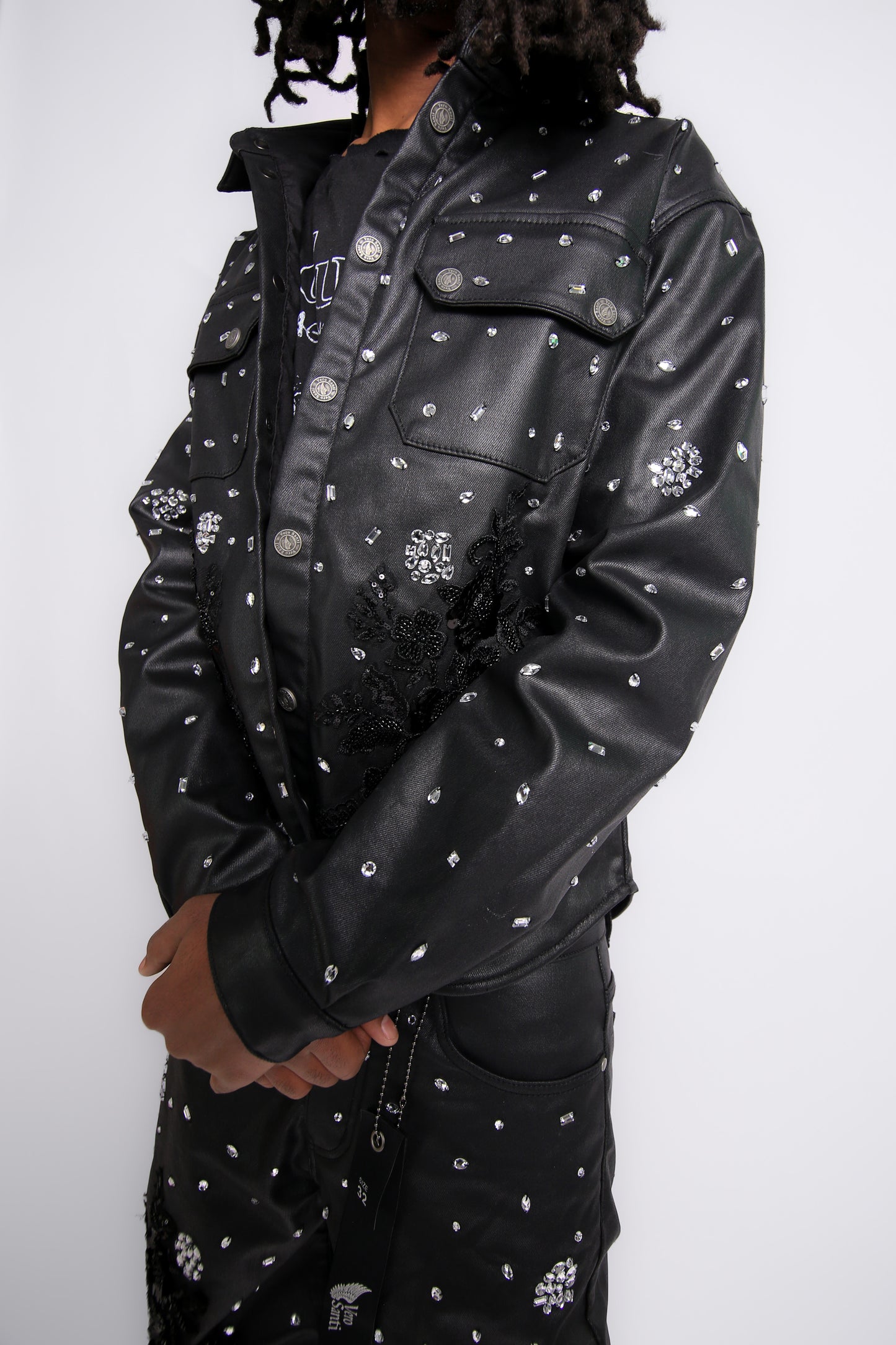 Person wearing a black leather jacket with white patterns on a white background