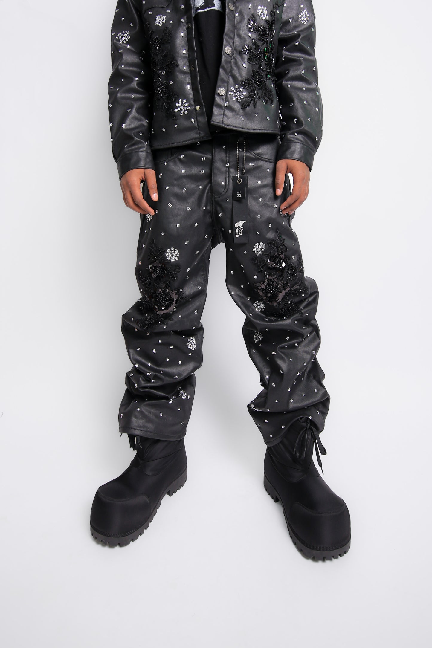Person wearing a black leather pants with white patterns on a white background