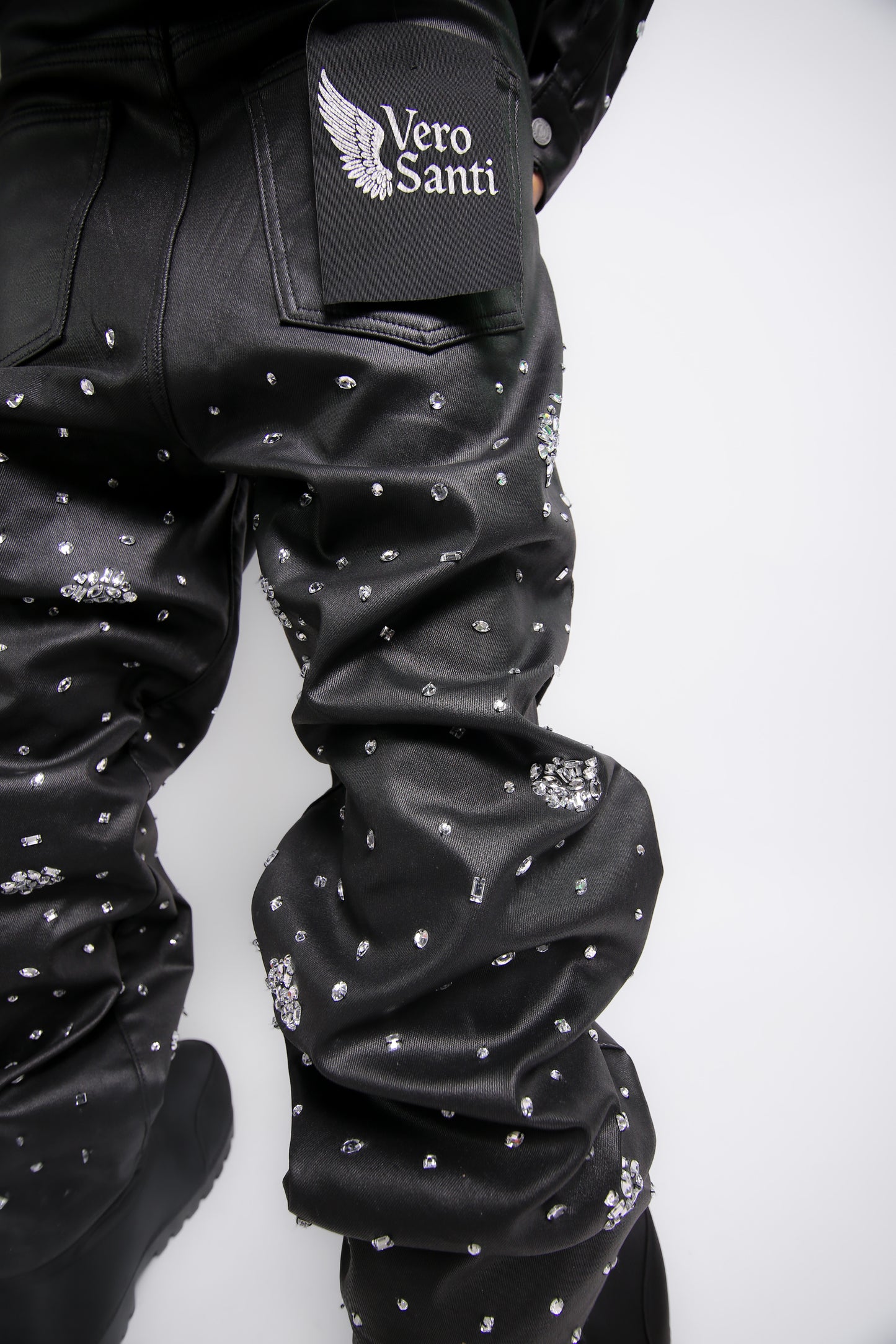 Black leather jacket with rhinestone embellishments and 'Vero Santi' logo on sleeve against a white background