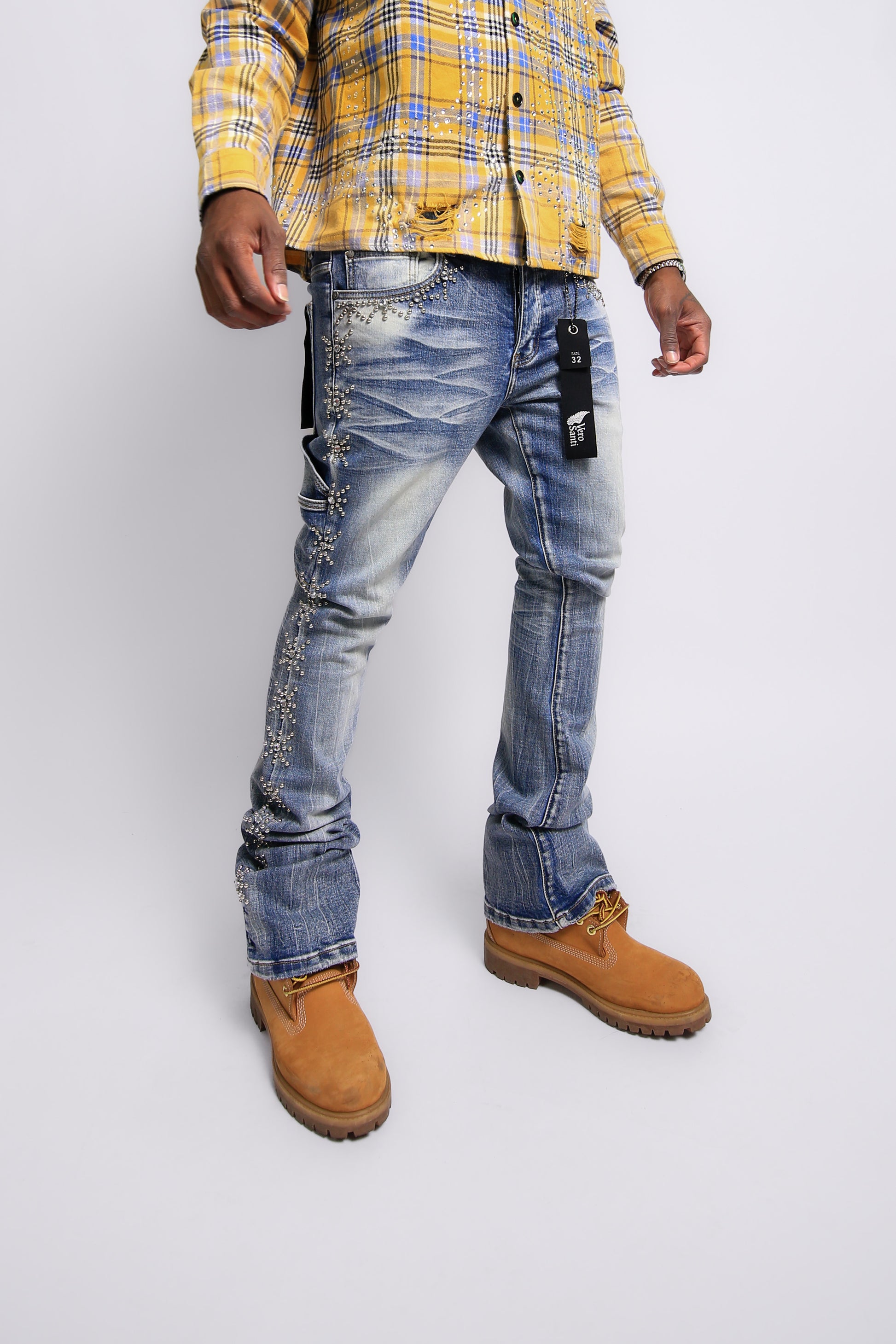 Person wearing a yellow plaid shirt, blue jeans, and brown boots on a white background