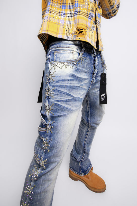Person wearing embellished blue jeans with a yellow plaid shirt on a white background