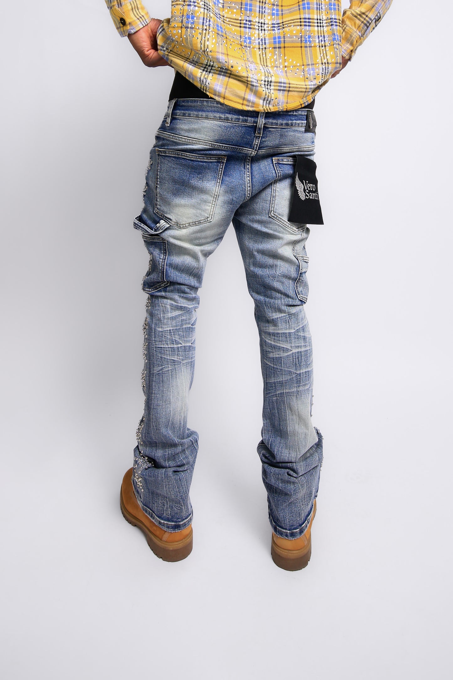 Person wearing blue jeans and a yellow plaid shirt on a white background