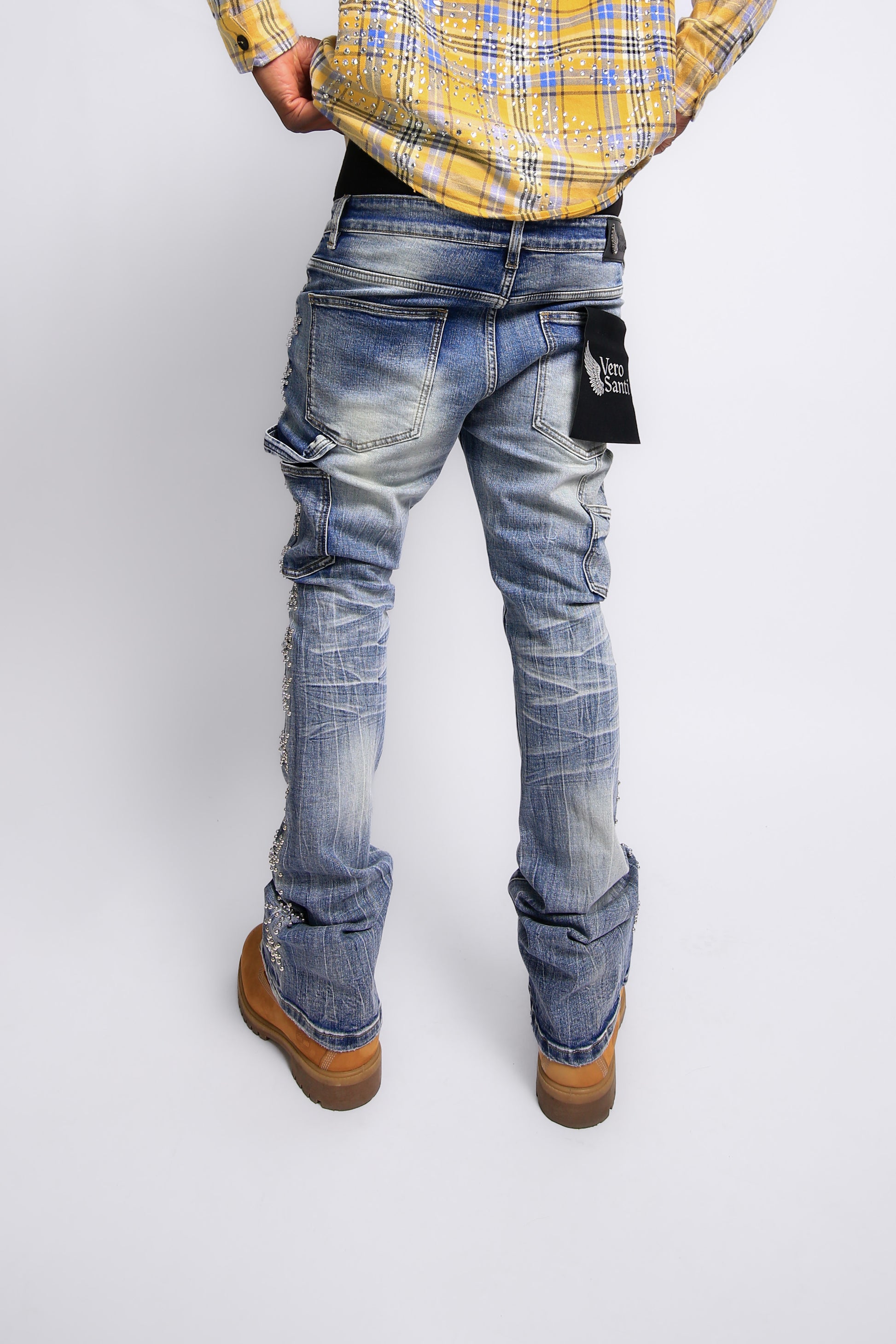 Person wearing blue jeans and a yellow plaid shirt on a white background