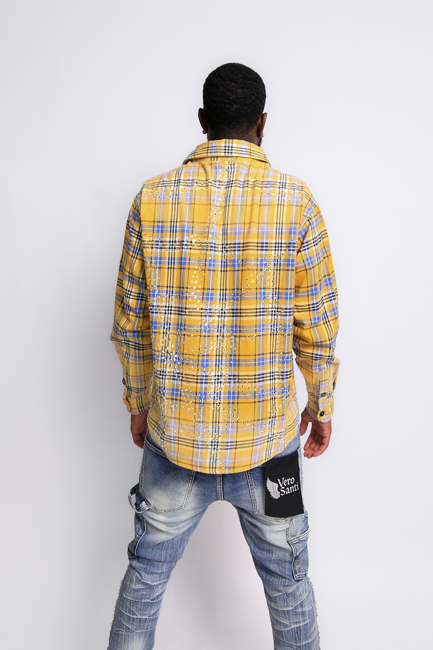 Person wearing a yellow and blue plaid shirt with a white background