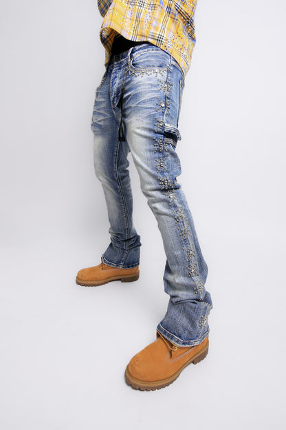 Person wearing blue distressed jeans and tan boots on a white background