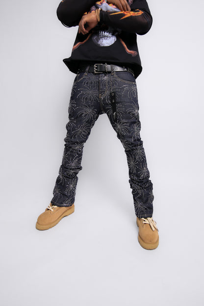 Person wearing black patterned jeans and a black hoodie on a white background