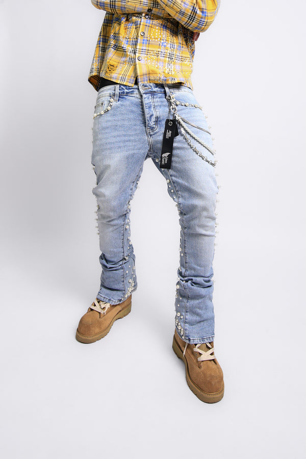 Person wearing light blue distressed jeans with a yellow plaid shirt on a white background